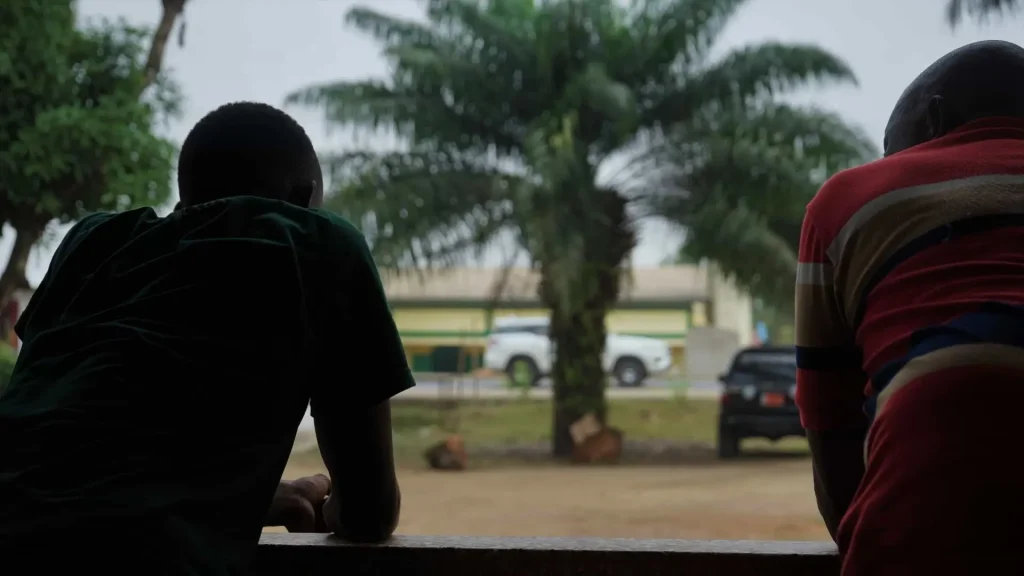 Two men from behind looking out over the countryside in Liberia
