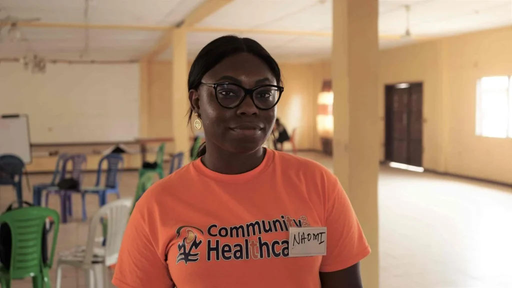 Naomi Solanke in a orange t-shirt looking into the camera